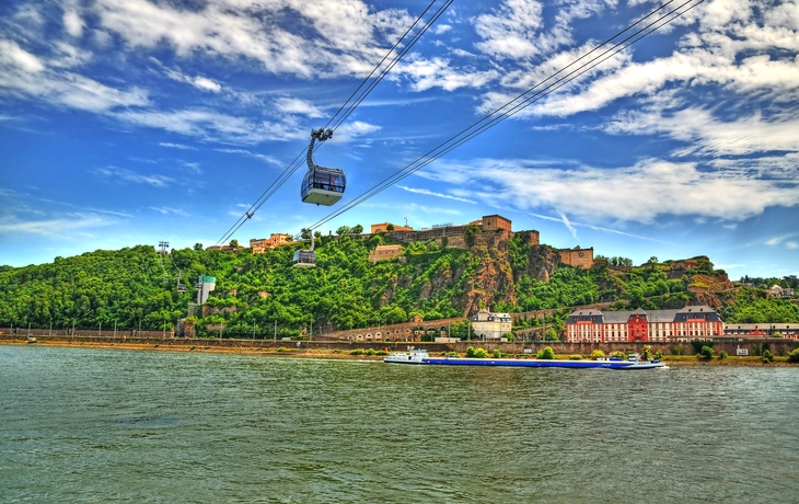 Schönes HDR-Bild der Festung Ehrenbreitstein auf dem Berg in Koblenz über dem Rhein mit den Drahtseilbahnen, die durch Berge sich bewegen.